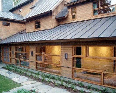 a beautiful, modern wooden house with a black metal roof