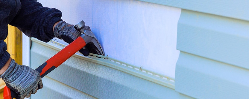 a contractor pries siting off of a house